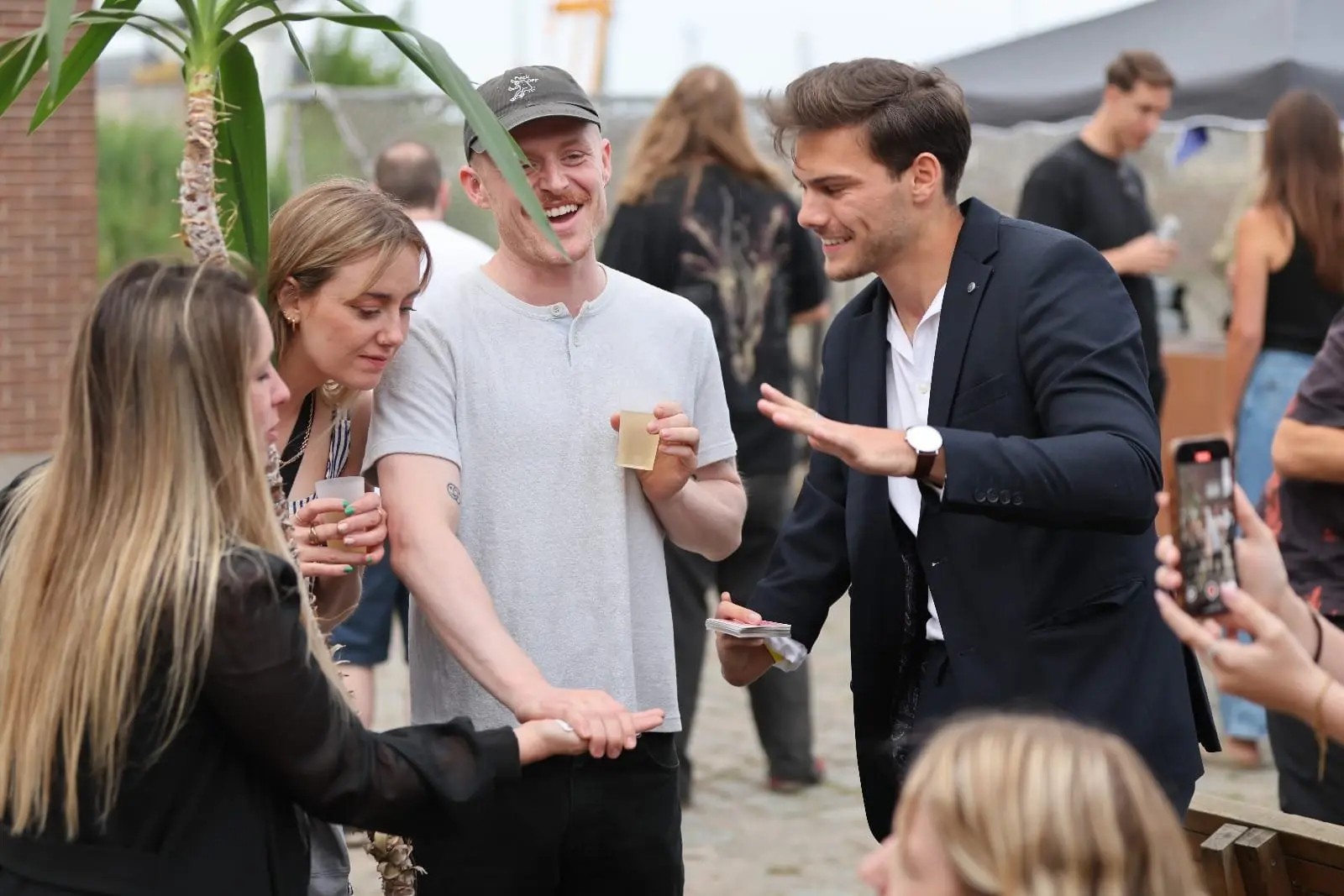 Wout De Sutter voert een interactieve kaarttruc uit voor enthousiaste gasten tijdens een buitenevent